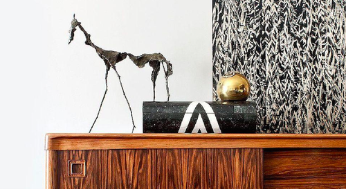 Abstract horse sculpture and black box on a wood side table