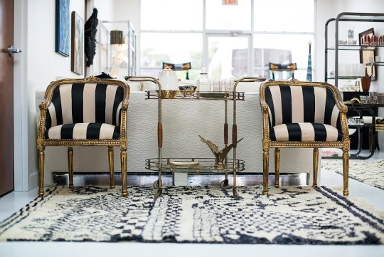 Louis-style black and white striped accent chairs with brass bar cart