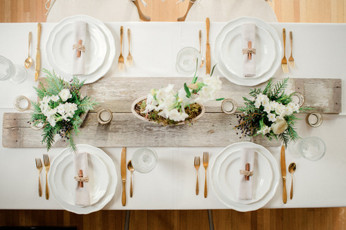 Organic Modern Dining Table with Driftwood Centerpiece and Brass Silverware.