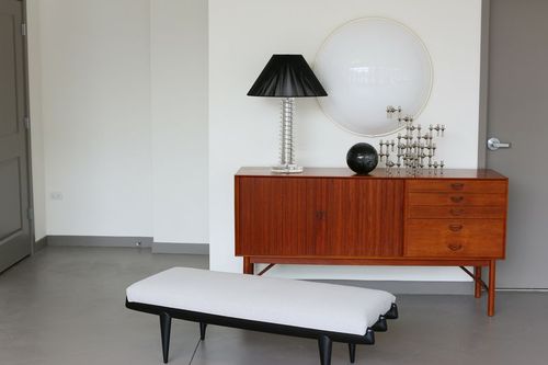 Midcentury-stile wood credenza and modern black bench with white cushion