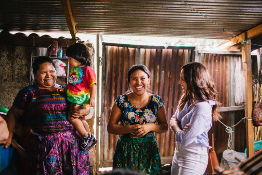 Sarah Contrucci Smith laughs with shopkeepers in Guatemala.