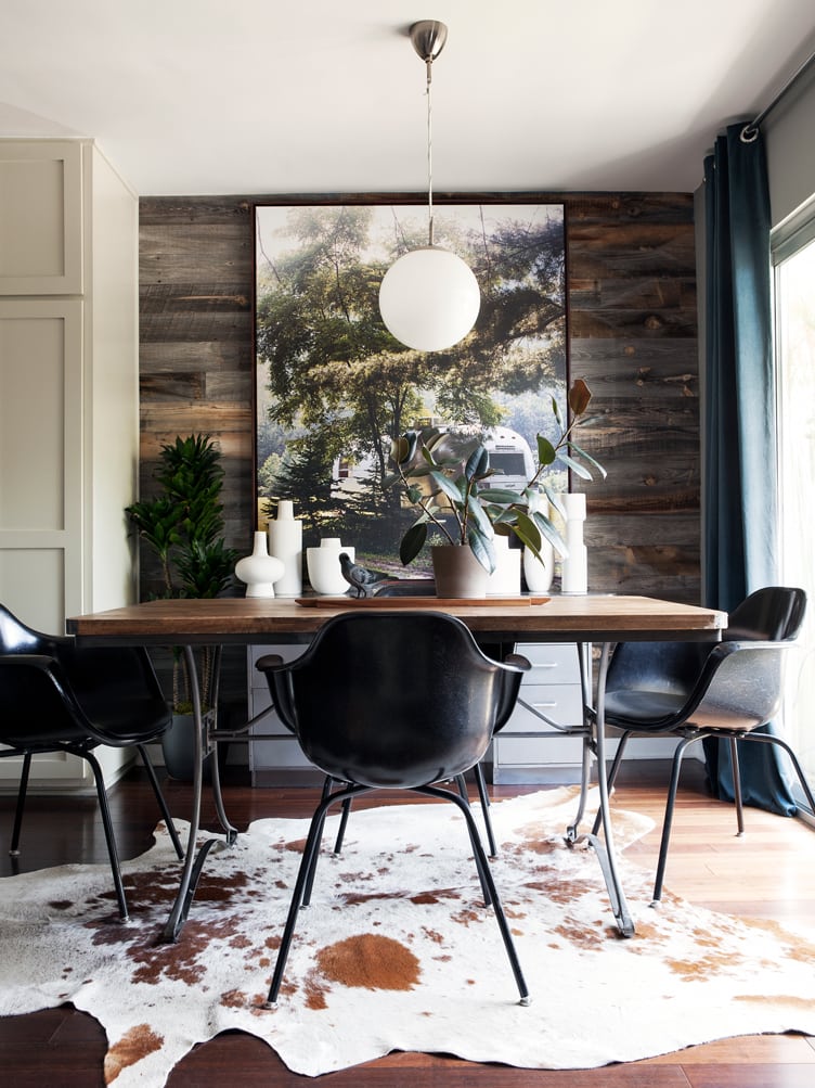 Mid-Century Modern Black Shell Eames Chairs in Rustic Dining Room with Cowhide Rug