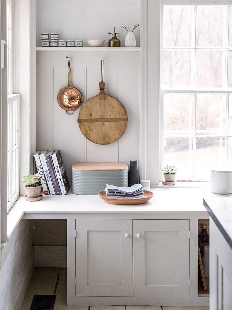 Farmhouse Kitchen Corner with White Cabinets and Brass and Wood Kitchenware.