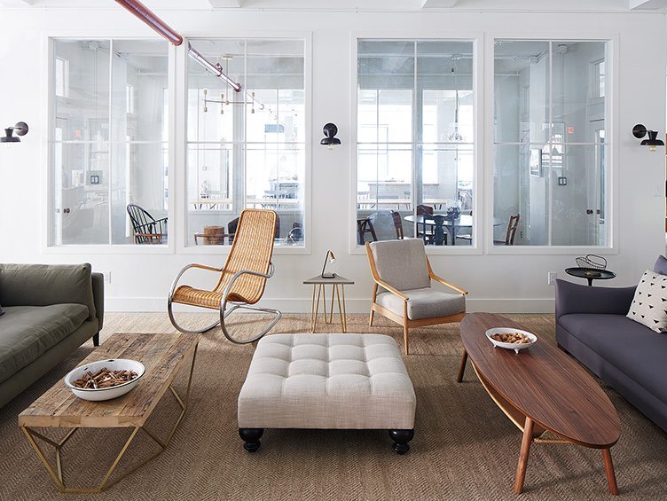 Cream colored modern chairs, wicker rocking chair with grey ottaman and rustic coffee tables