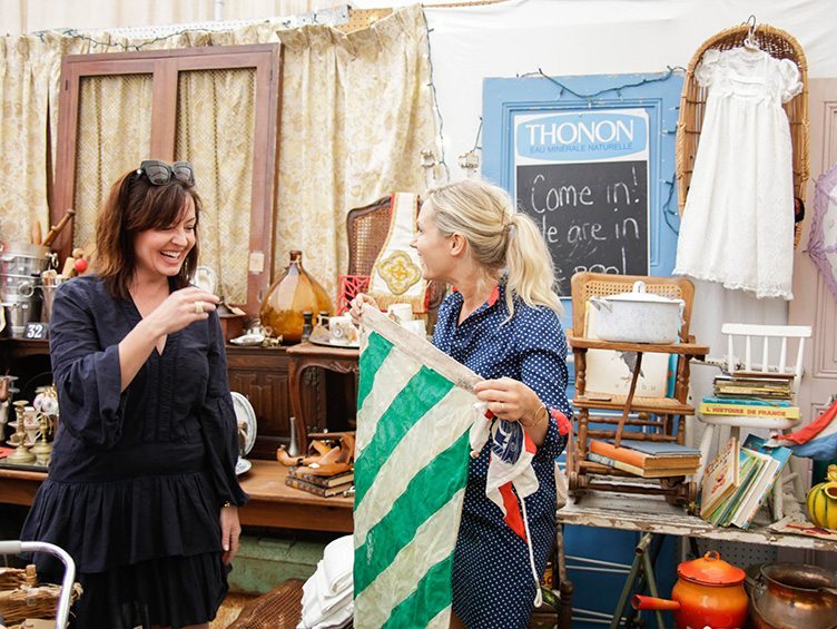 Emily Henderson shows Anna Brockway a green and beige striped textile.