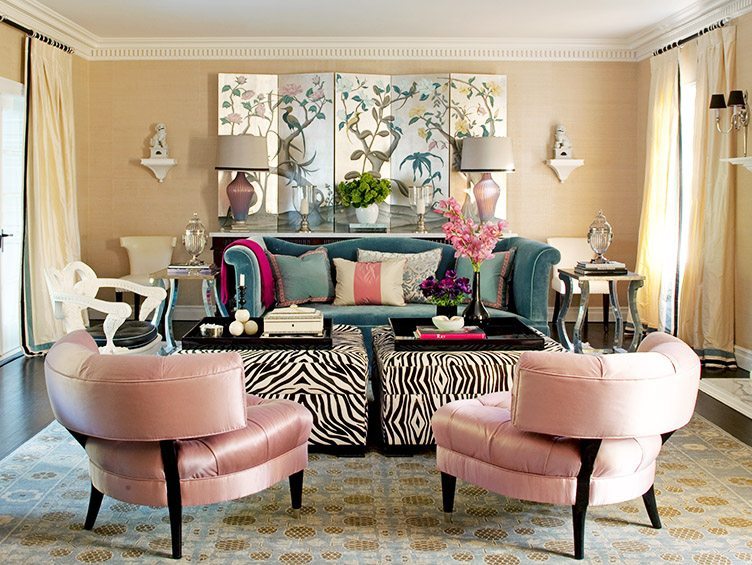 Pink slipper chairs in glamorous living room with zebra print coffee tables and Asian panelling on the walls.