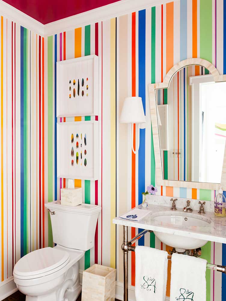 Master bath with a rainbow striped wallpaper and two matching contemporary art pieces