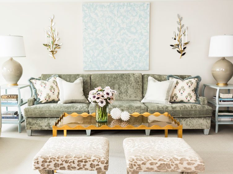 Sage sofa, cheetah print ottomans, twin blue accent tables, and eclectic orange coffee table in living room