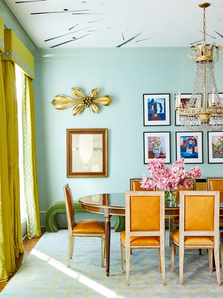 Eclectic Dining room with Gallery Wall and Orange Satin Chairs and Crystal Chandelier 