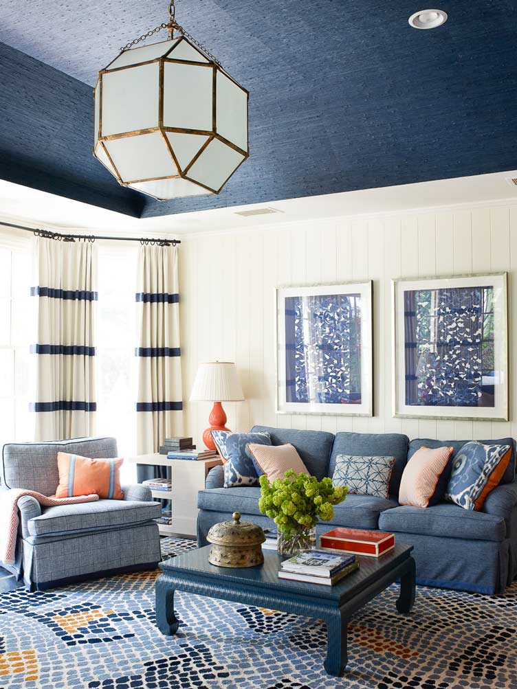 Living room with blue wallpapered ceiling and geometric light fixture