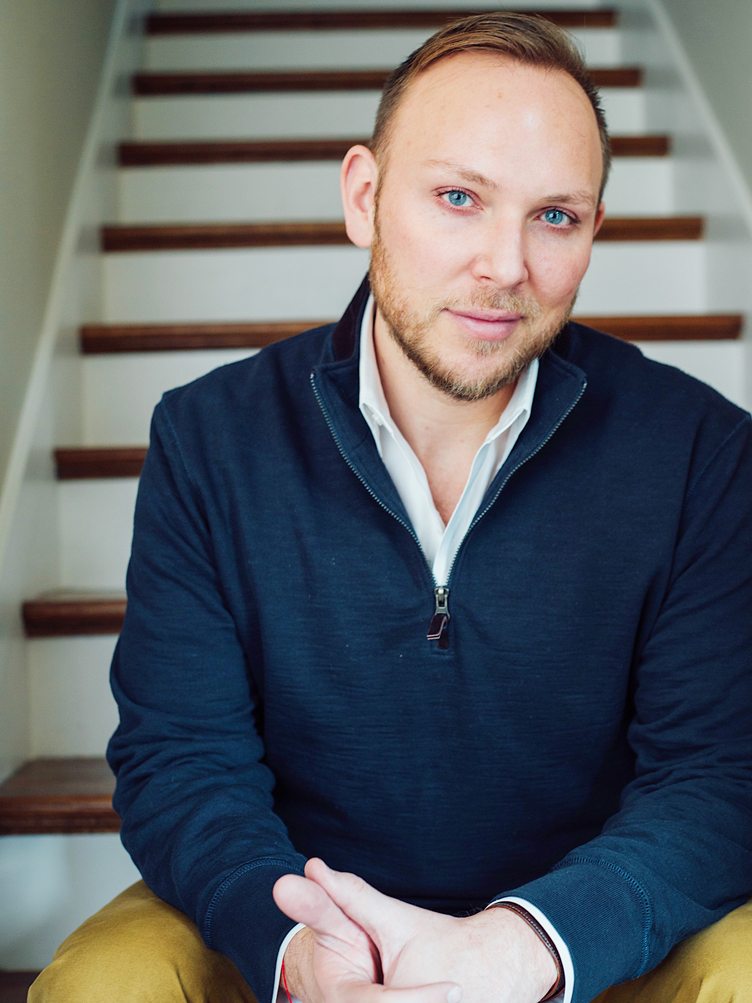 Chad James sits on white and wood staircase in portrait on Chairish 