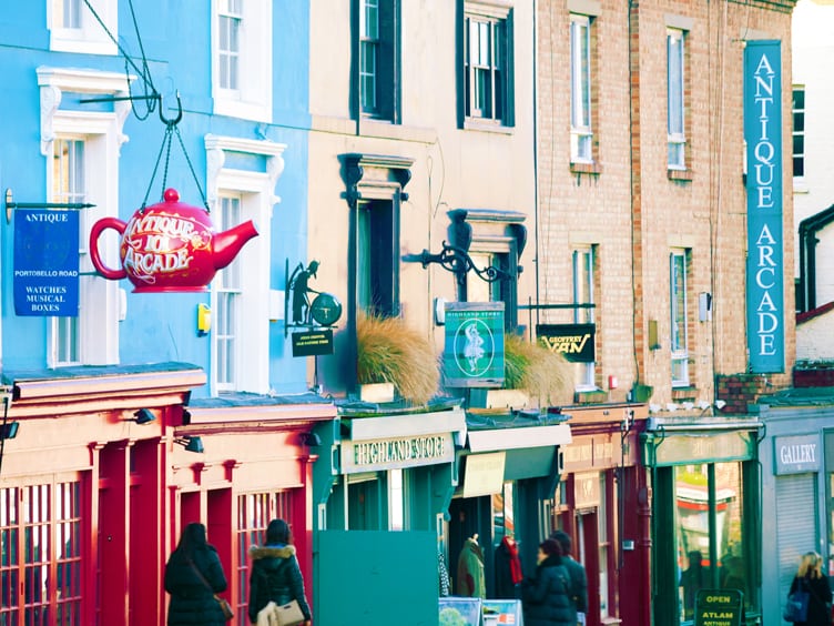 Row of brightly painted buildings and store signs on busy street