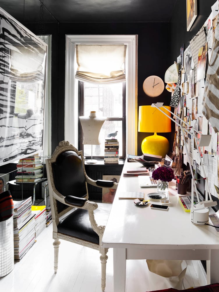 Black office with traditional armchair, white desk, and yellow table lamp