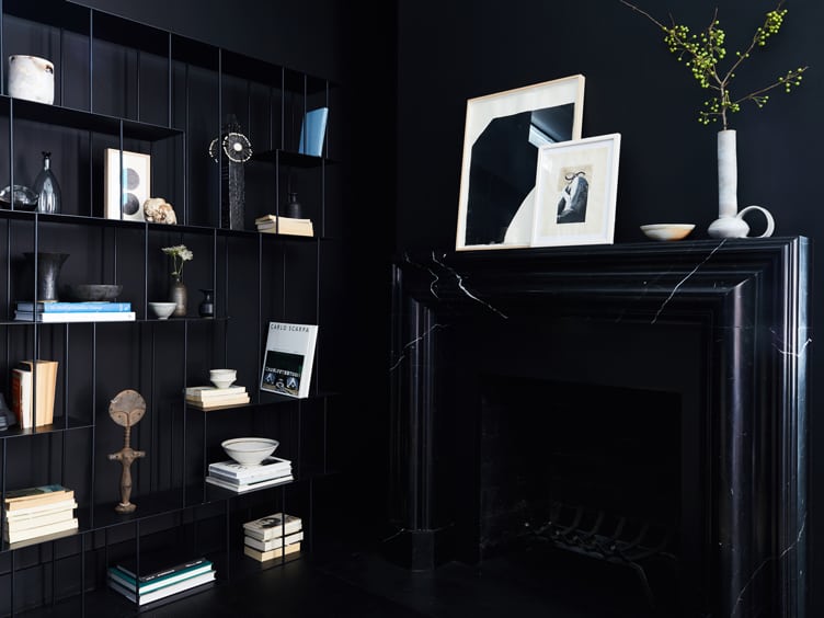 Living Room with Black Walls and Modern Black Metal Bookshelf and black Marble Fireplace.