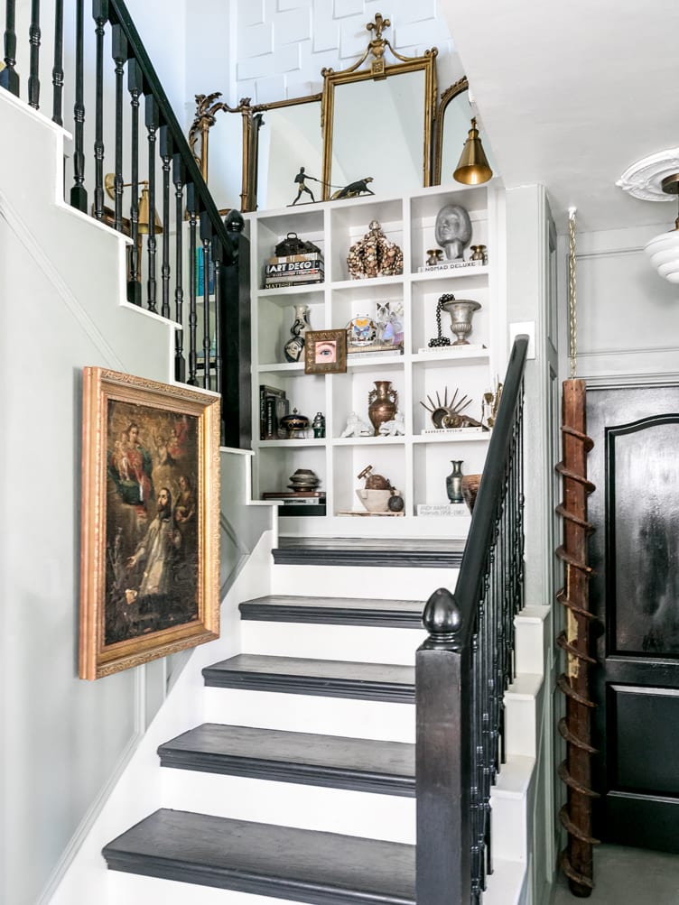 Home Stairway Decorated with Eclectic Collection of Metal Vases and Vintage Artwork