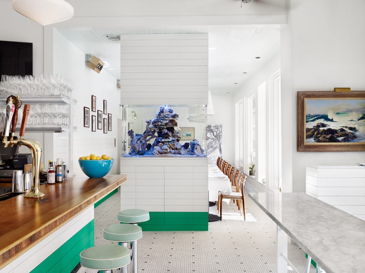 Green bar stools at bar, and wooden dining chairs in kitchen/bar