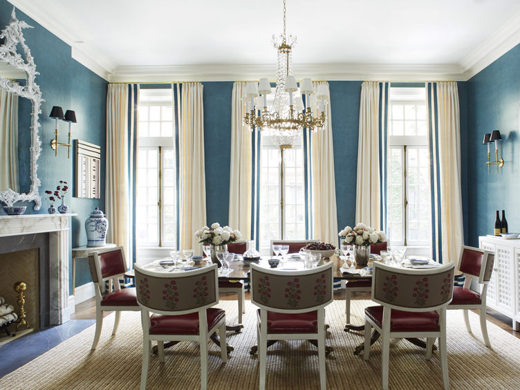 Traditional blue dining rooms with crystal chandelier and ornate mirror with leather dining chairs