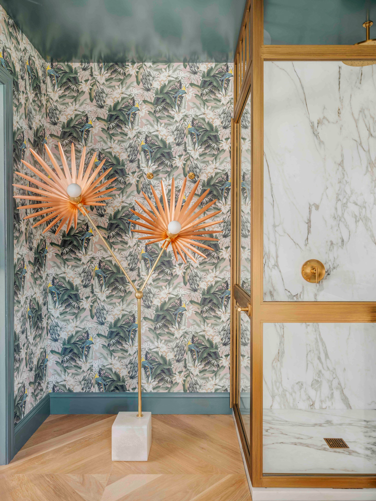 Bathroom with foliage wallpaper and sculptural starburst standing lamp