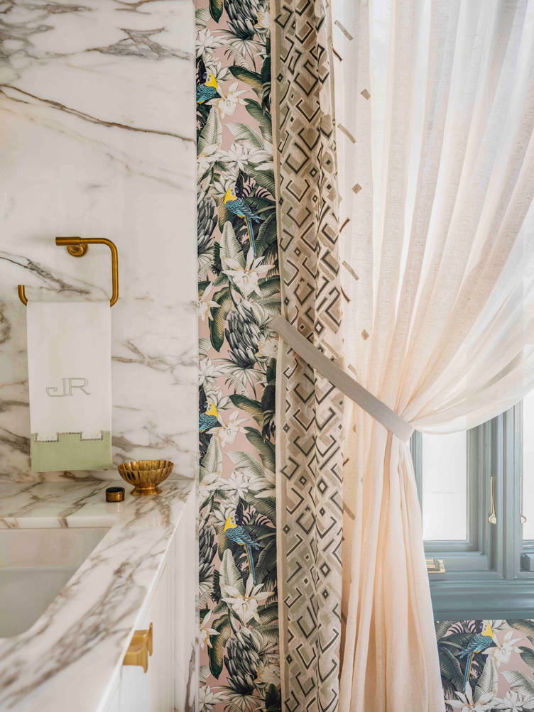 The patterned curtains in this bathroom were pulled back on the floral wallpaper 