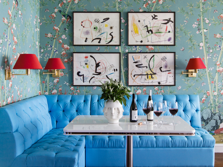 Breakfast nook with blue tufted bench seating and floral wallpaper 