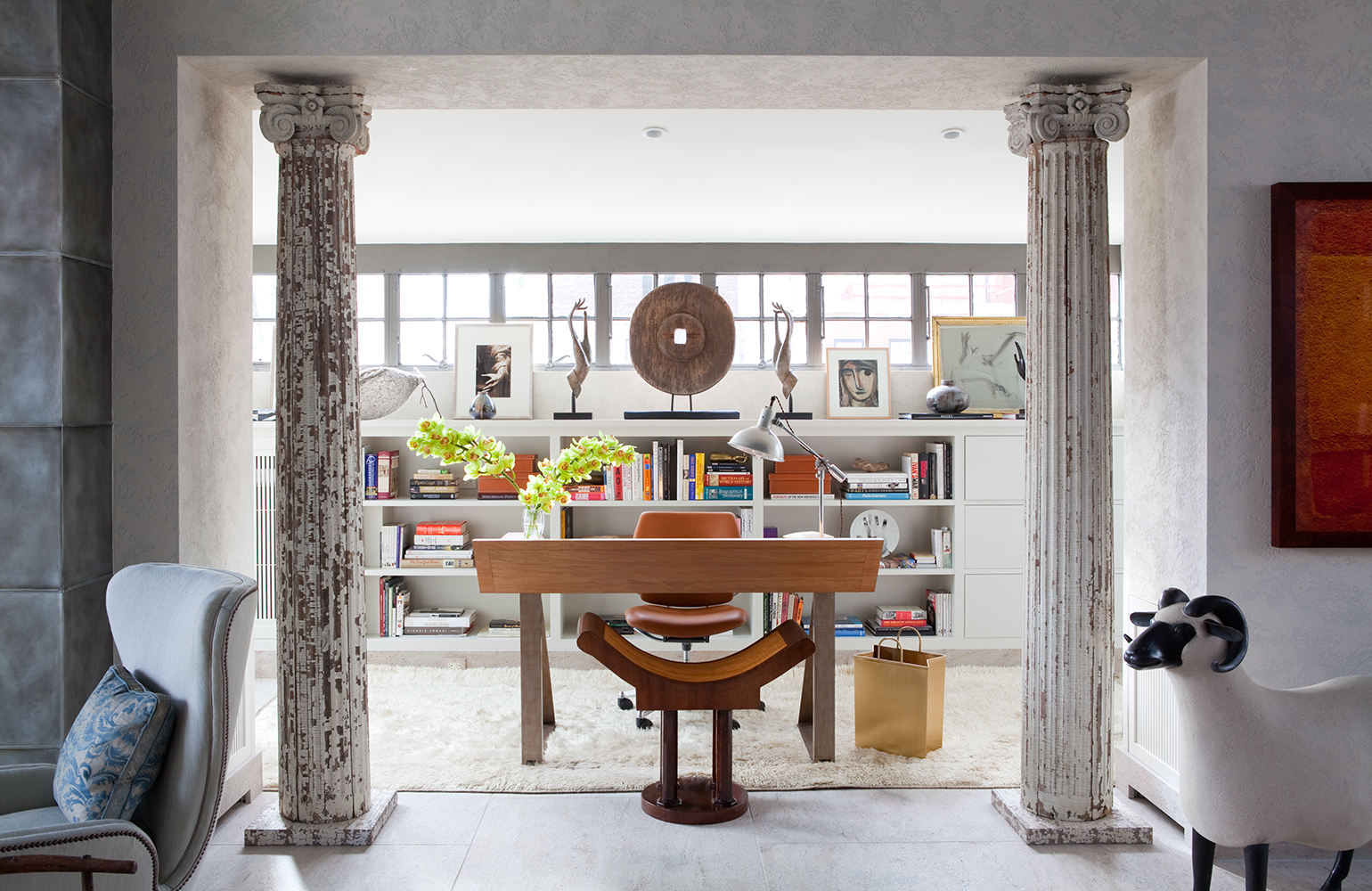 Office area with wood desk, distressed white columns, and ram sculpture 