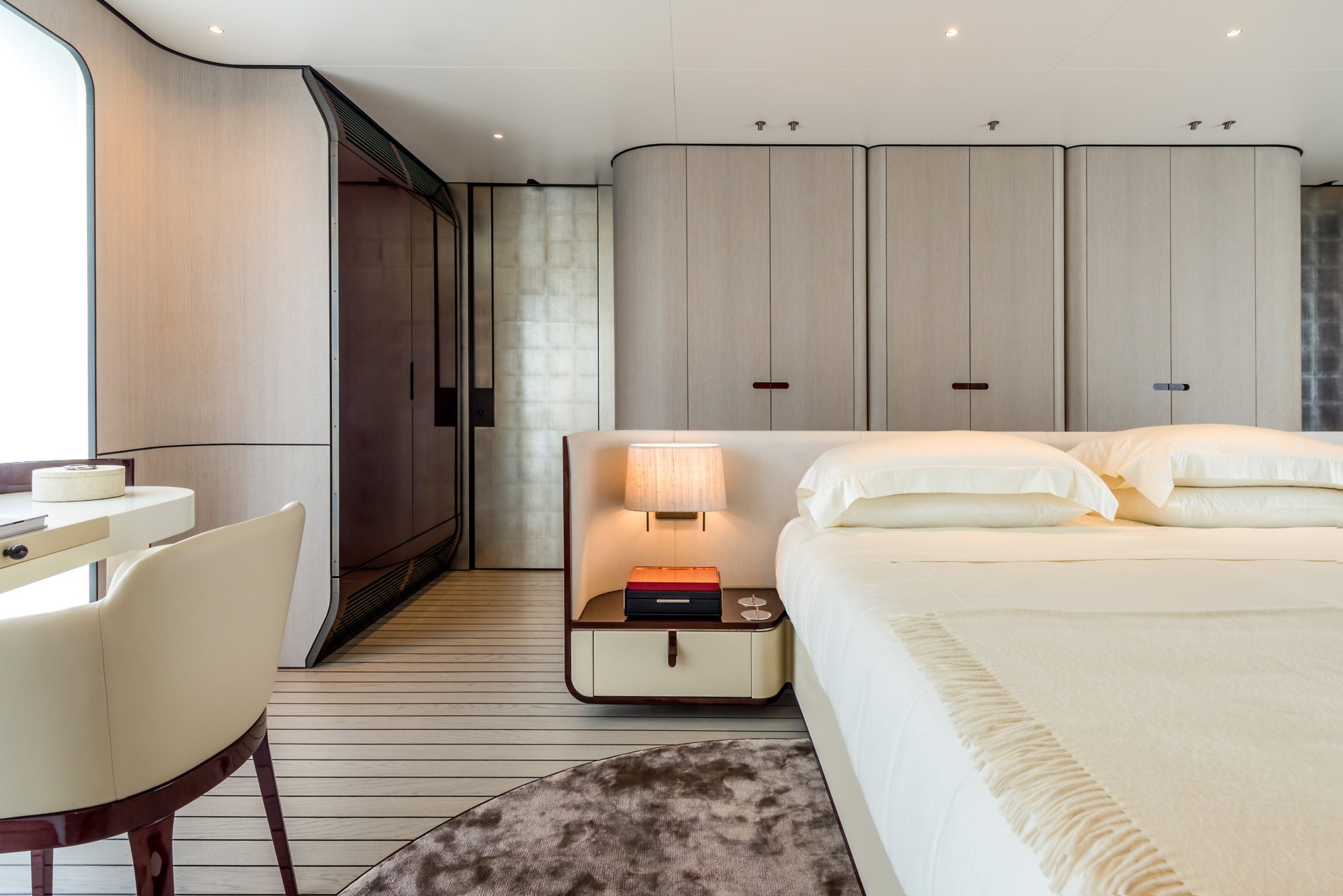 Modern bedroom on a yacht with gray wood closets and brown rug