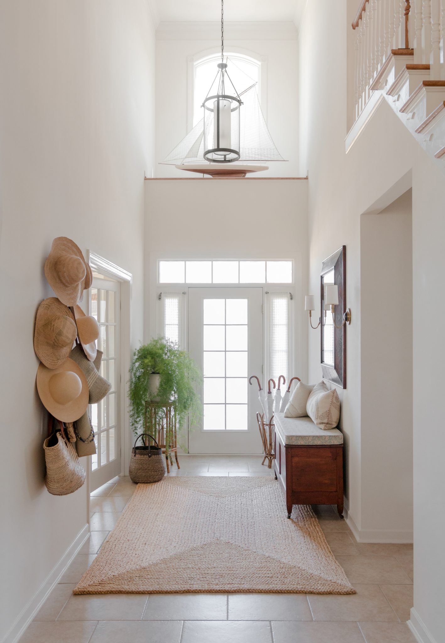 Bright entryway with natural fiber rug, hanging submits, and woven basket bags.