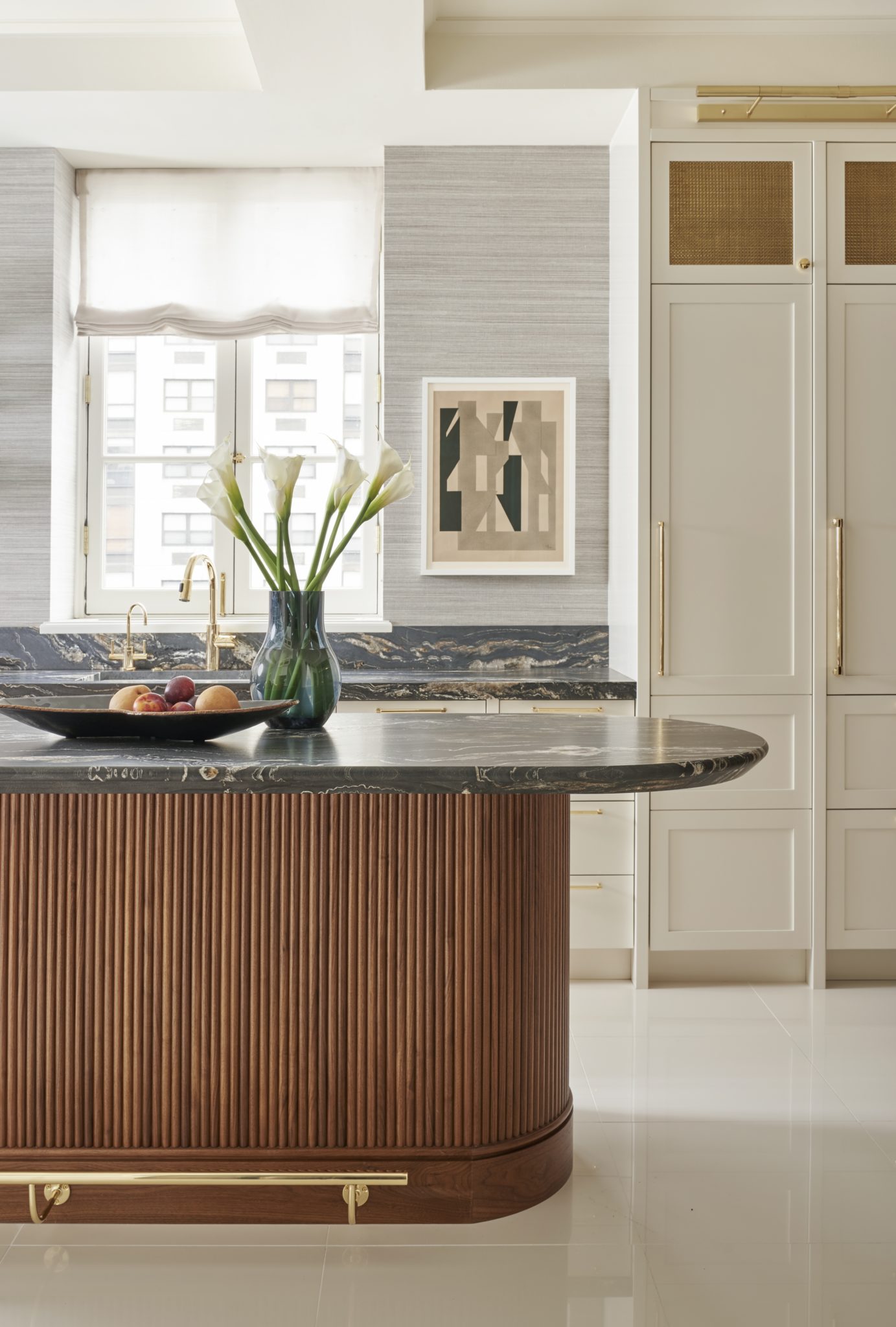 Wood kitchen island with gray marble countertop and glass vase with ceramic fruit bowl