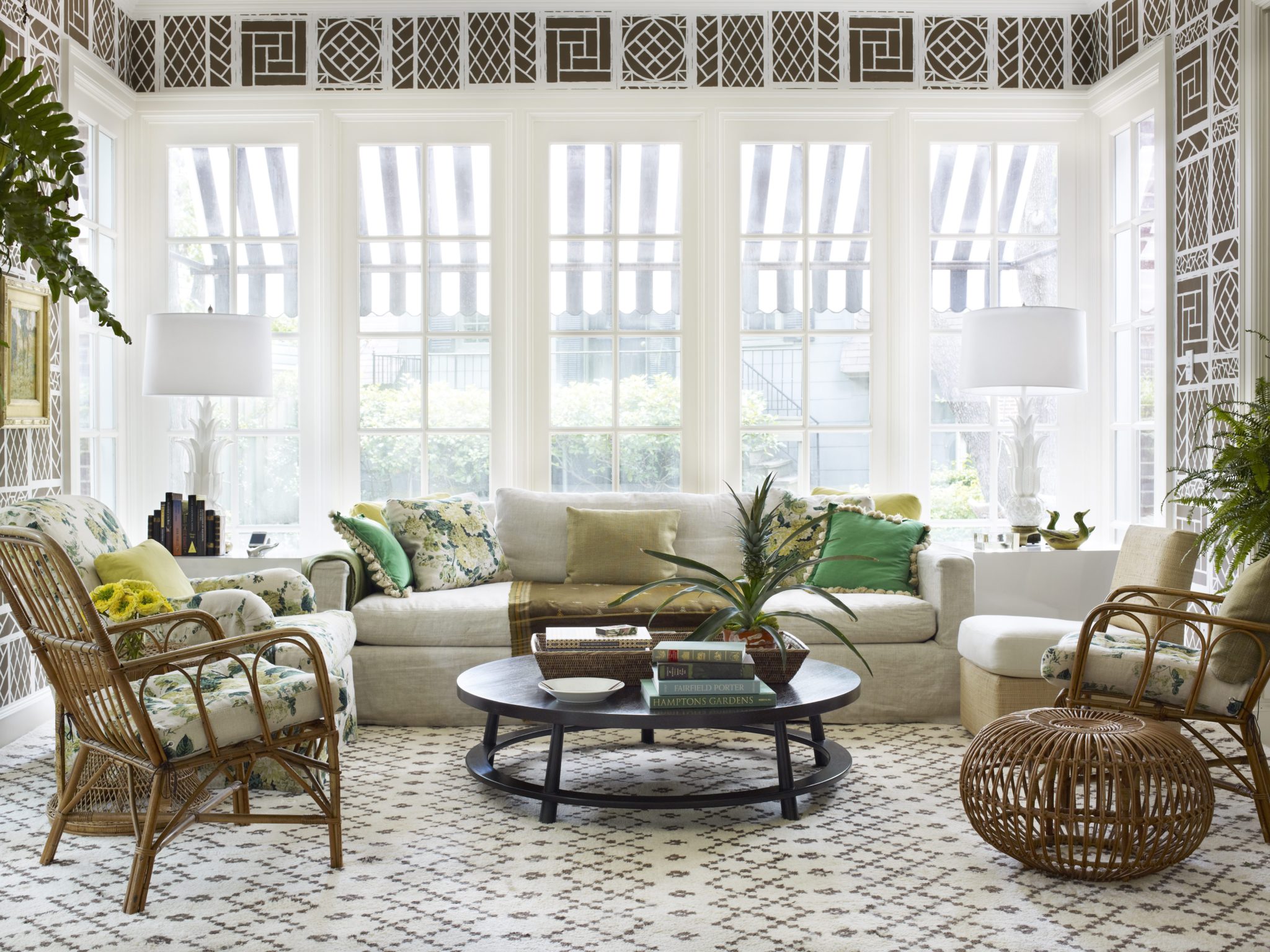 Beachy living room with rattan ottoman and matching armchairs with floral prints 