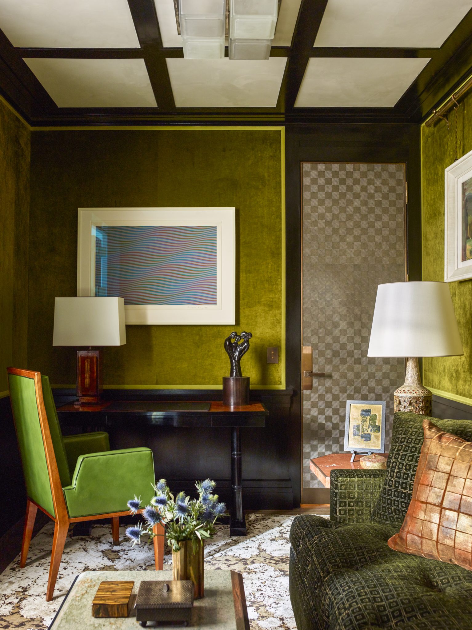 Sitting room with textured chartreuse wallpaper and dark wood wainscoting with green seating