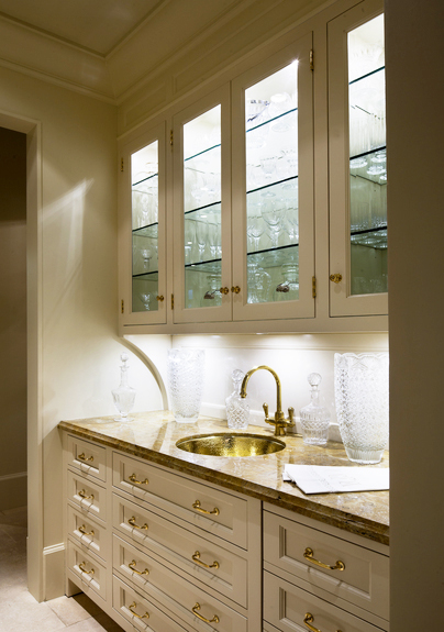 Traditional butler's pantry with gold hardware and sink with cream cabinetry