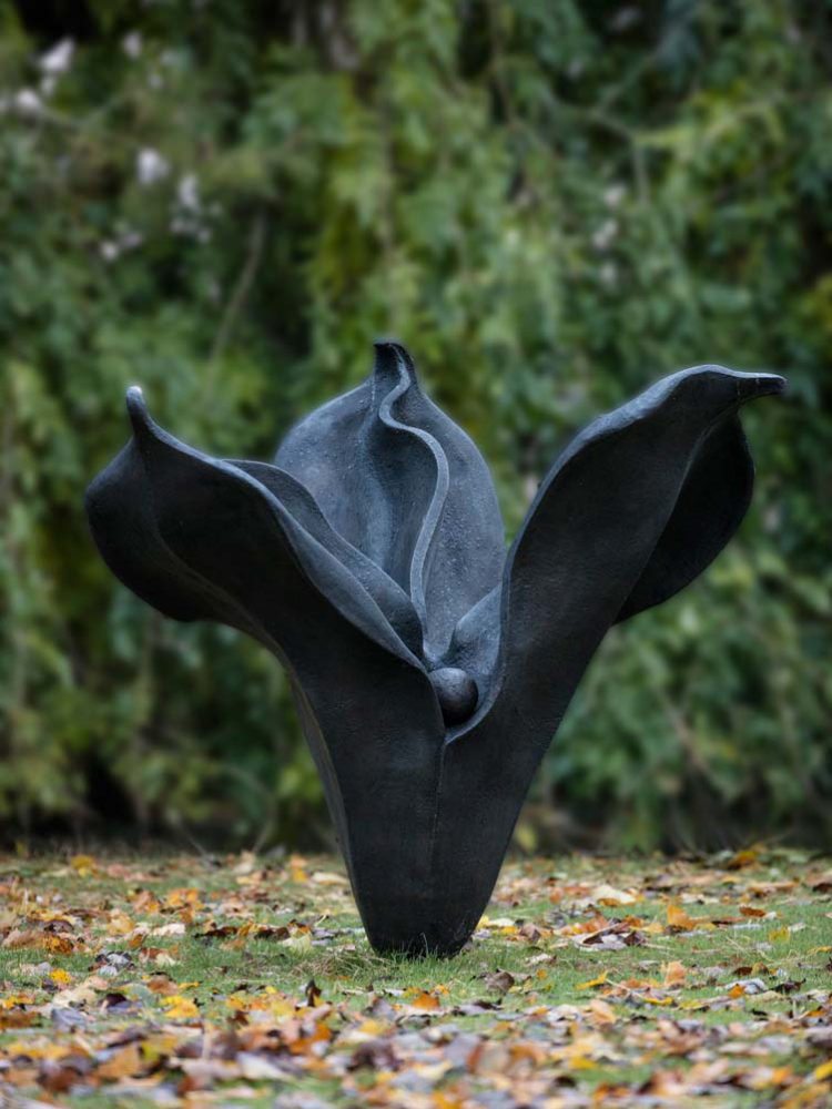 "La Promesse" a large, yonic floral sculpture in black in a garden.