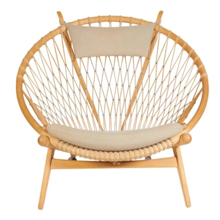 Hans Wegner circle chair with wood frame, rope back, and beige seat and head cushion