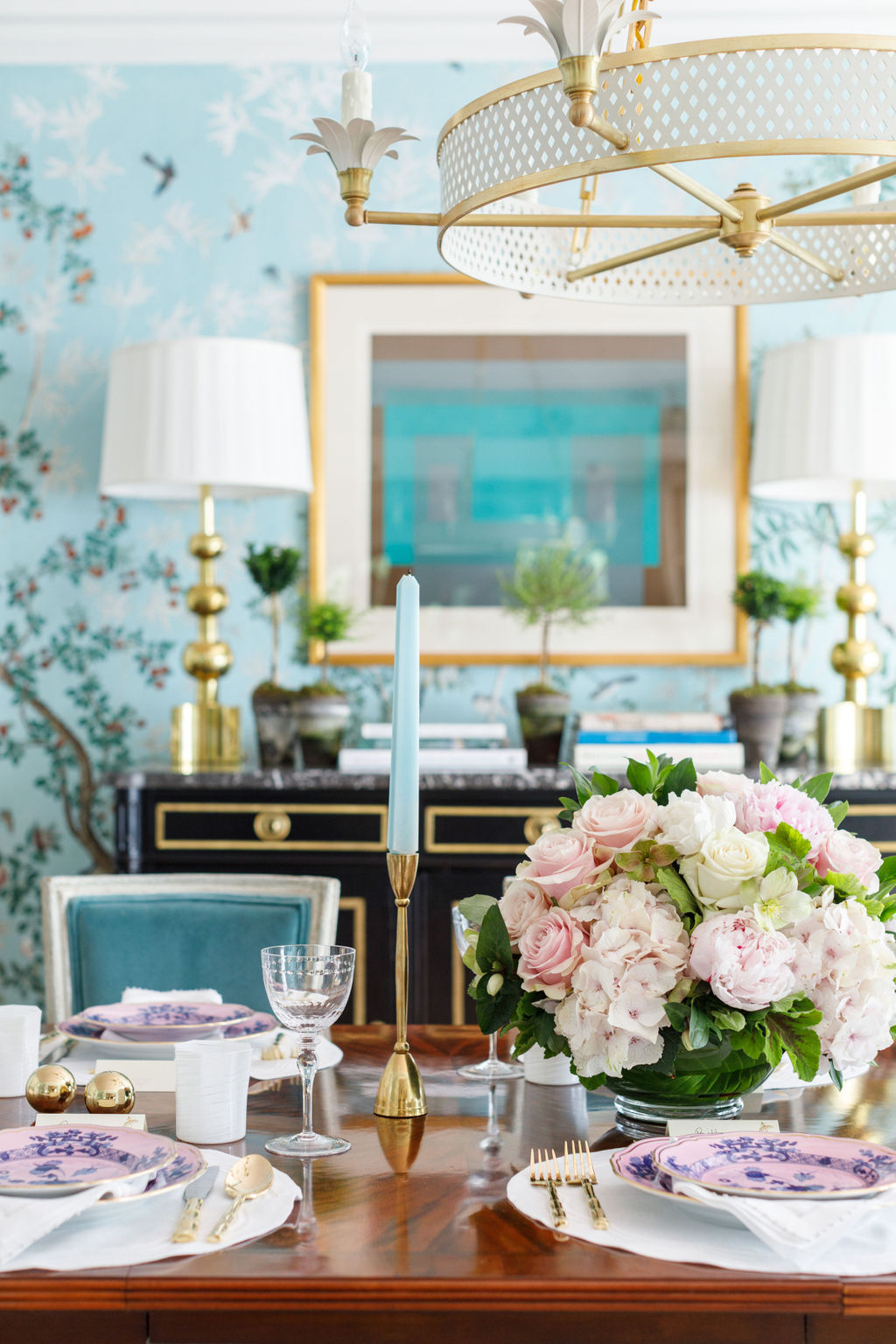 Table scape with brass candlesticks and pink china, and floral arrangement 