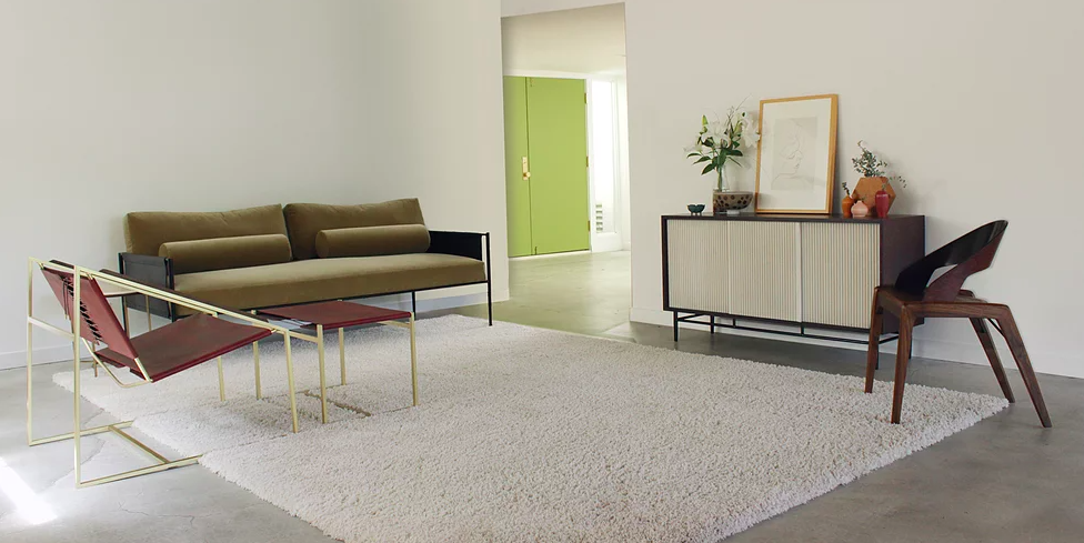 Minimalist living room with credenza and moss-green velvet sofa from Fluxco