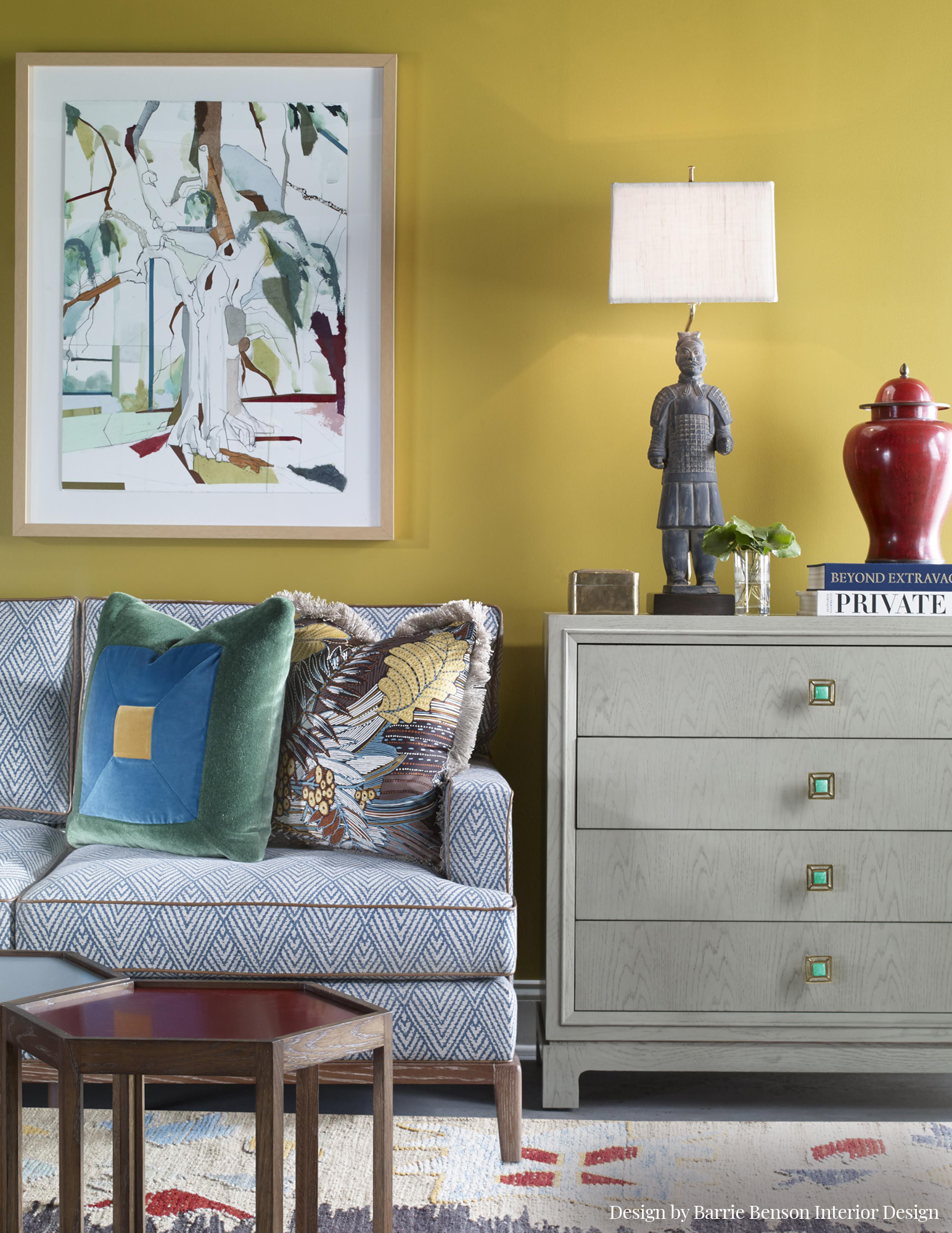 Mustard living room with blue patterned sofa, gray wood side table, and geometric coffee table