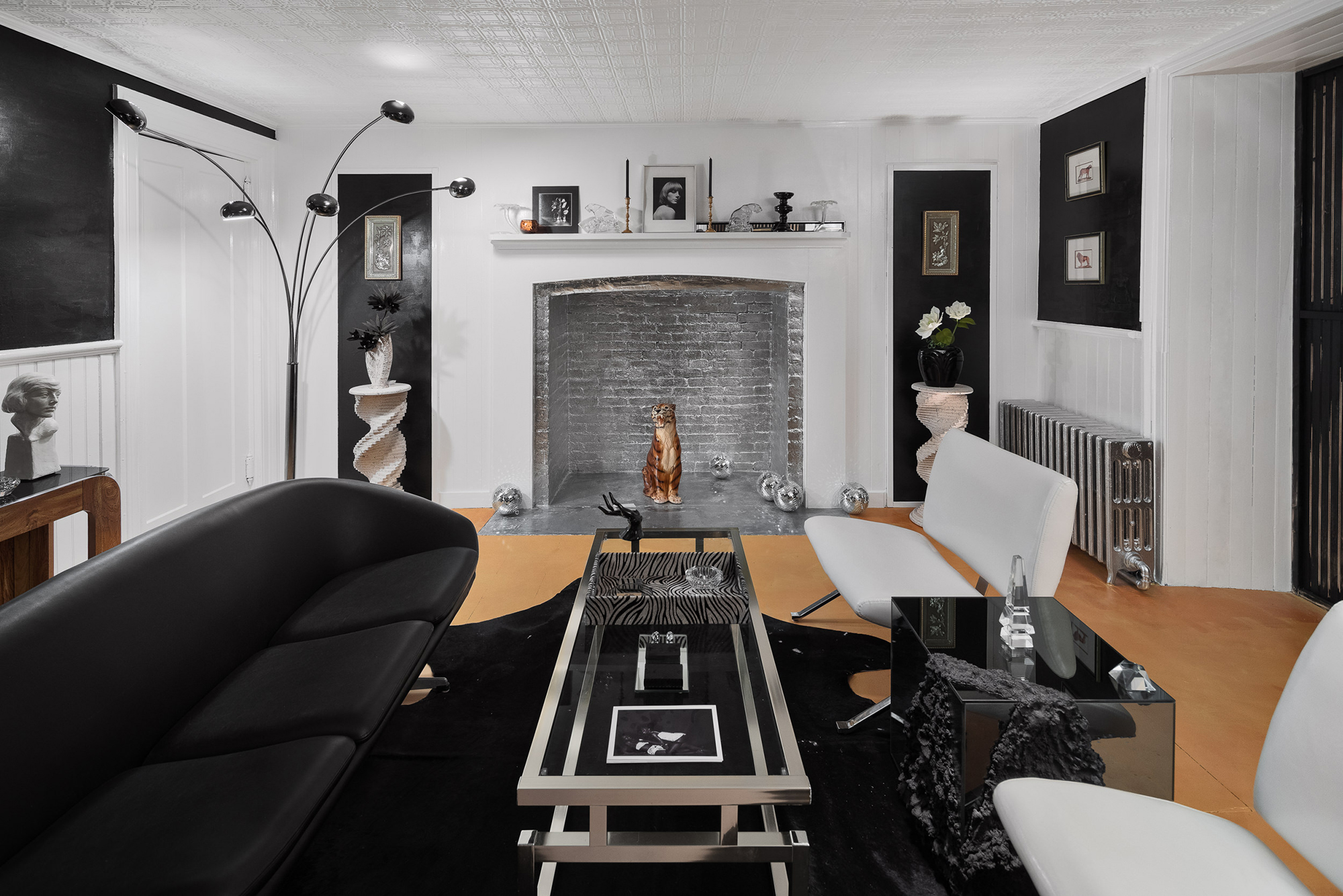 Living room with futuristic couch and love seats in black, white, and silver color scheme.