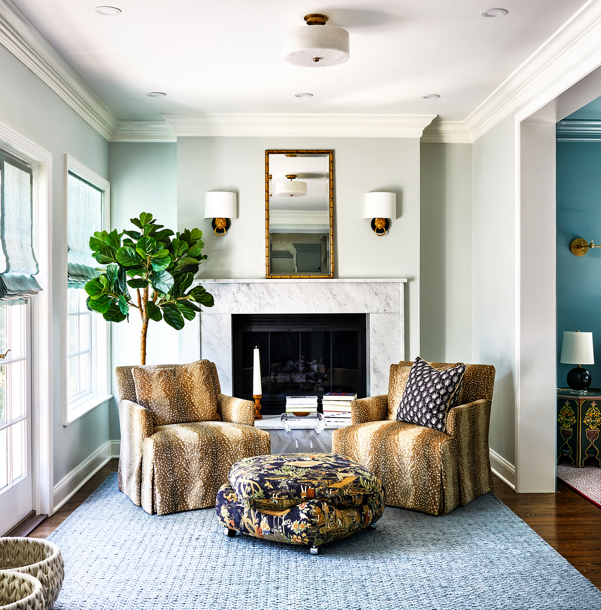 This bright seating area features a printed ottoman and matching brown speckled armchairs.