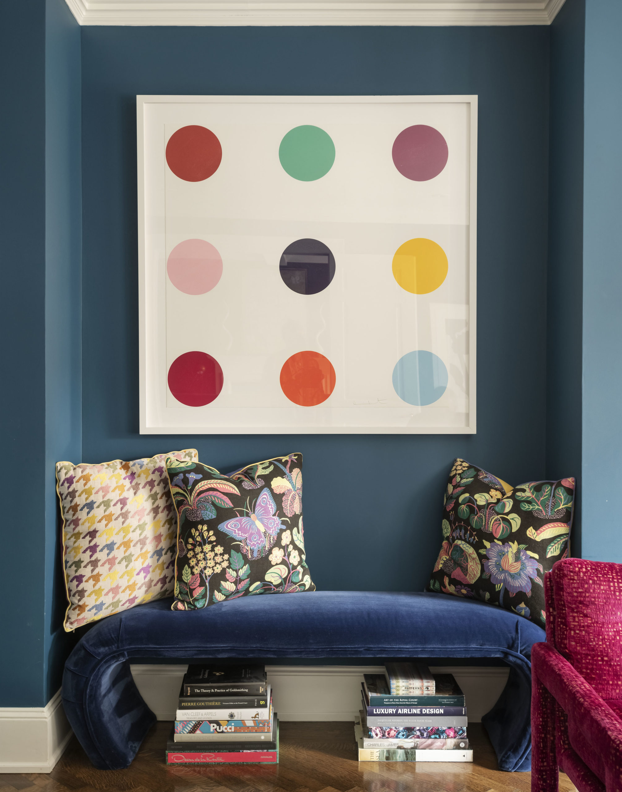 Brent Neale apartment with blue velvet bench, printed throw pillows, and pop art painting.