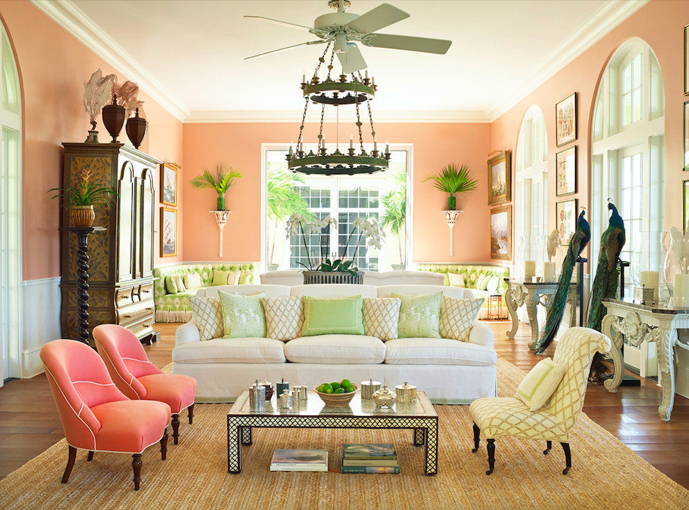 Living room with peach walls, green accents, and a cream couch.