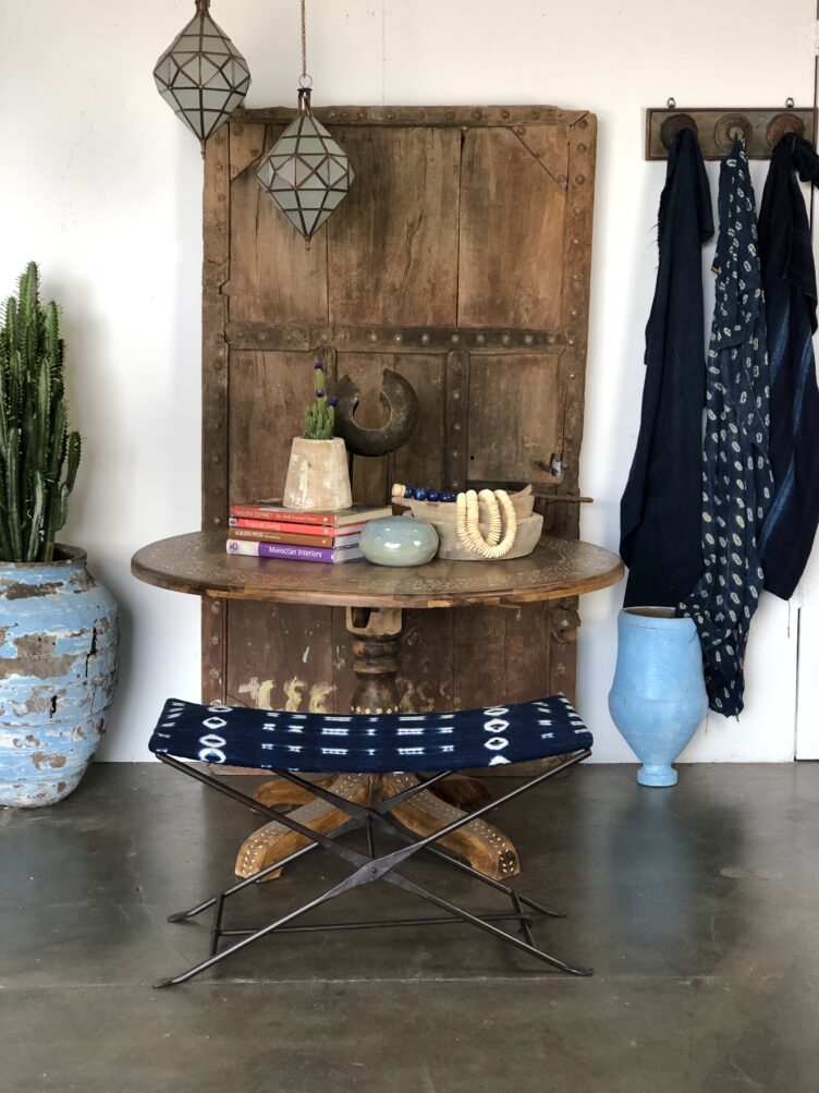 Round wood table with indigo print bench and ceramic vases and planters 