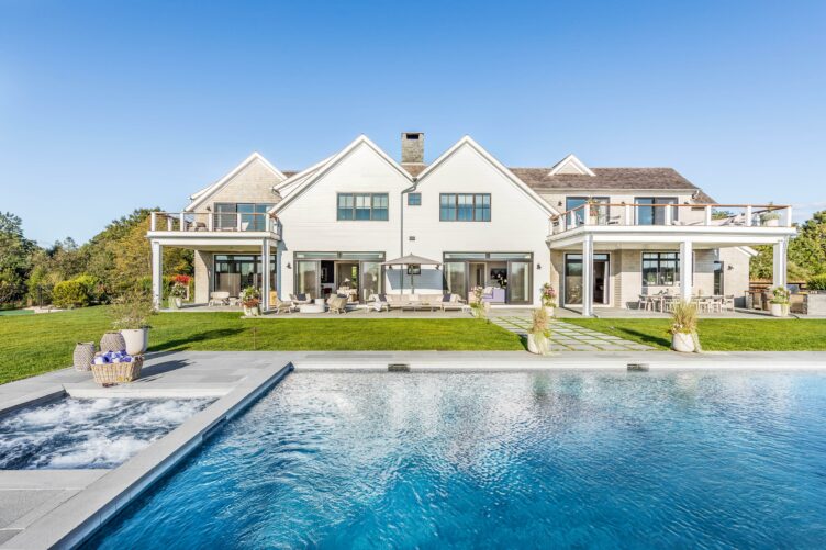 Large home's backyard with pool and jacuzzi by Katie White Interiors.