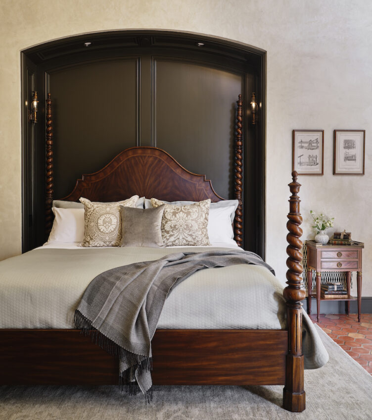 This dark wood four-poster bed is striking with the rooms light textiles and black accent wall.