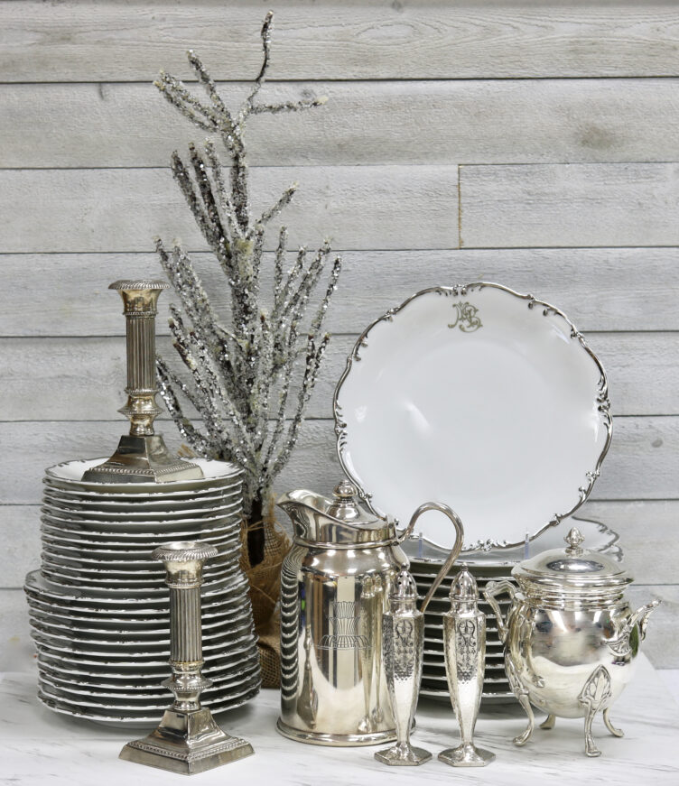 silver-rimmed china plates and silver candlesticks and serving tools on sale at Rose Victoria