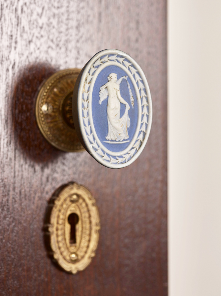 Neoclassical blue wedgwood antique door knob on vintage door with vintage keyhole cover