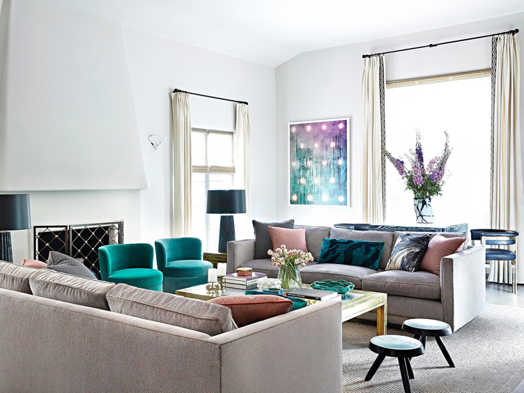 Modern living room featuring green velvet swivel chairs and matching gray sofas or loveseats