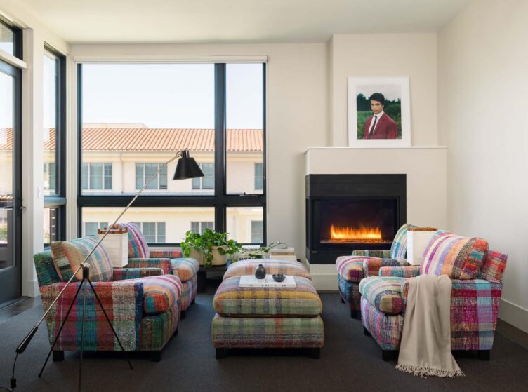 Living room with madras plaid inspired sofa, chair, and ottoman coffee table accented with a modernist floor lamp